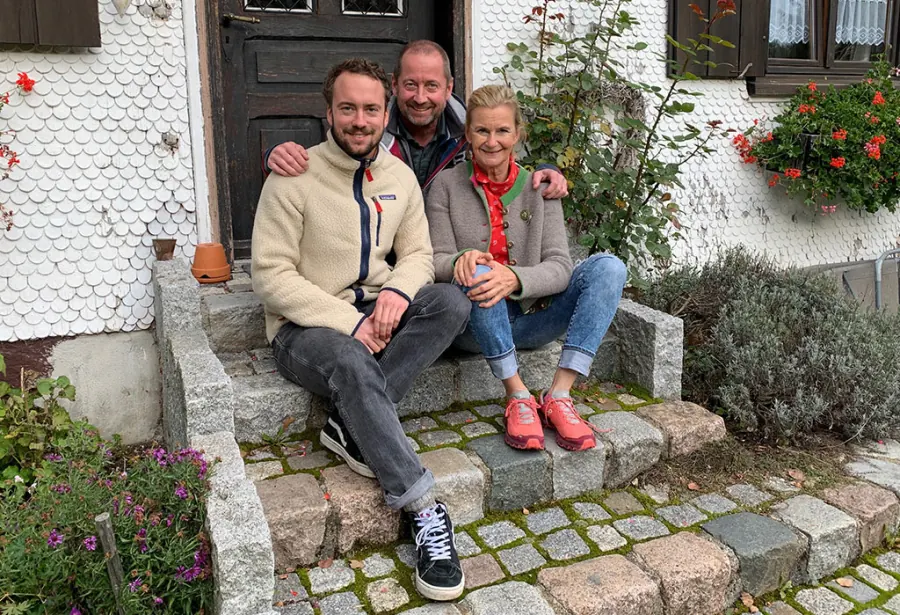 Michel, Pia und Niklas sitzen vor der Haustür des Bauernhauses
