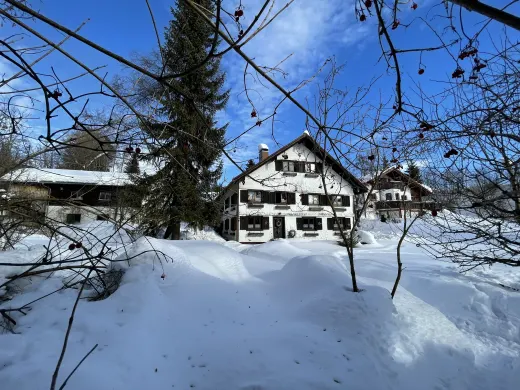 Blick durch den verschneiten Garten auf das Haus